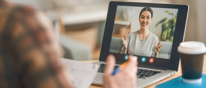 A person talking to a person on a computerDescription automatically generated